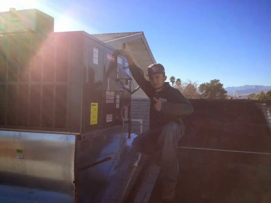 HVAC technician performing AC Tune-Up on a rooftop unit in Lackawanna